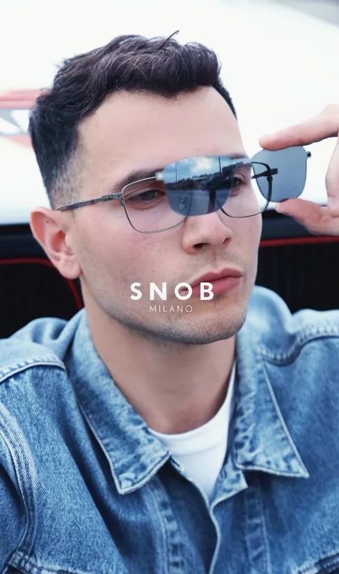 Homem a levantar o clipe de sol de uma armação metálica Snob Milano